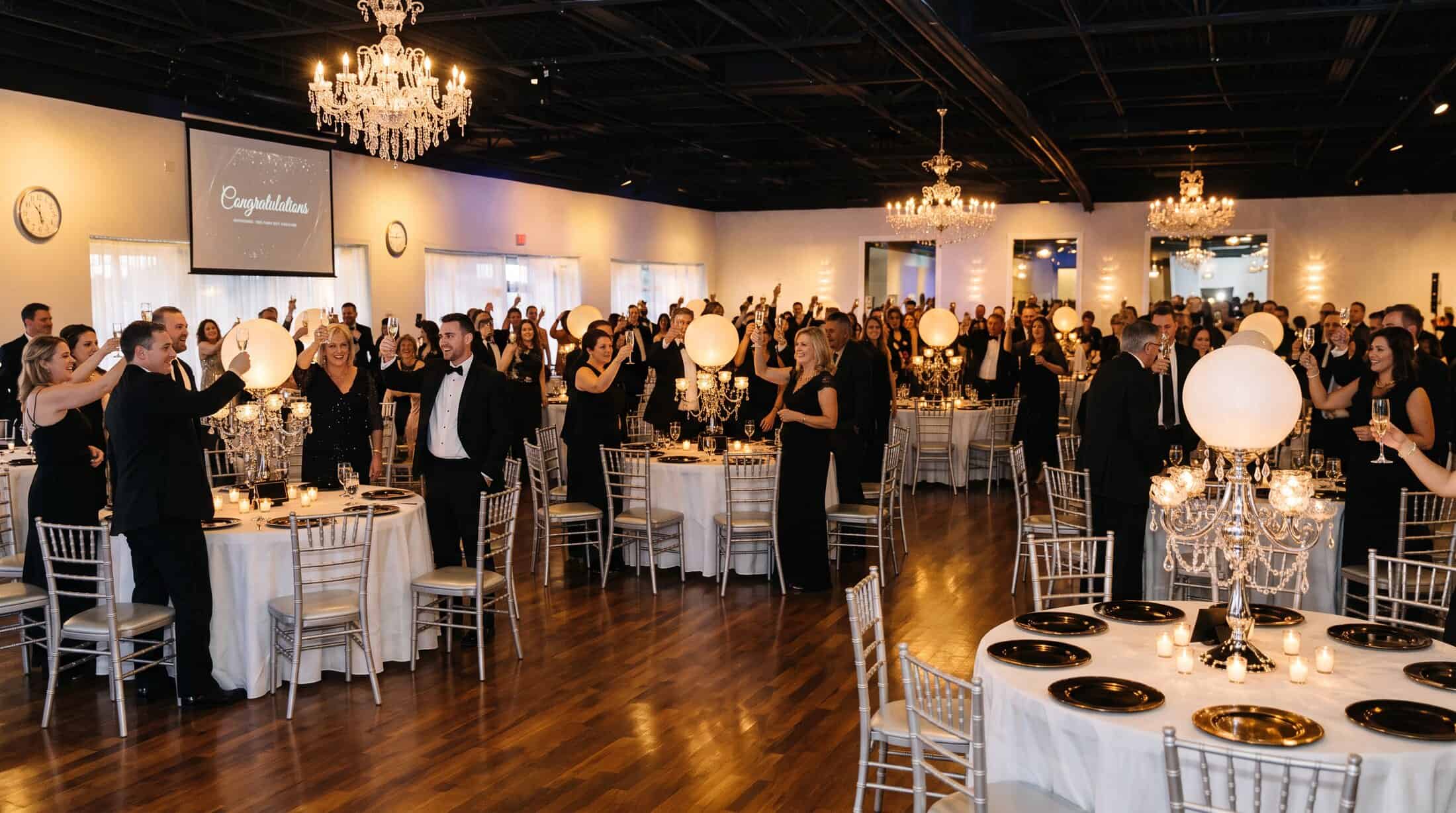 Guests toasting at a private celebration at Pizazz Ballroom